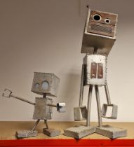 Two scrap built model robots, one with light up eyes