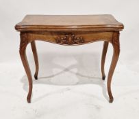 A Victorian mahogany folding card table of serpentine form opening to reveal a green baize top