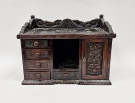 Stained wooden table-top cabinet, the outer decorated with carved geometric and floral motifs