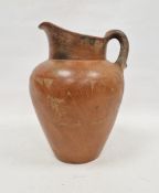 Large 20th century terracotta redware oviform water jug, incised with a band of fish amongst water