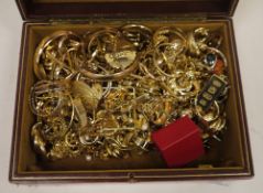 Quantity gold coloured metal jewellery, earrings and other items in a gilt leather jewel box.