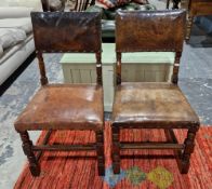 Two Cromwellian-style oak and leather dining chairs having brass studded leather panel back and