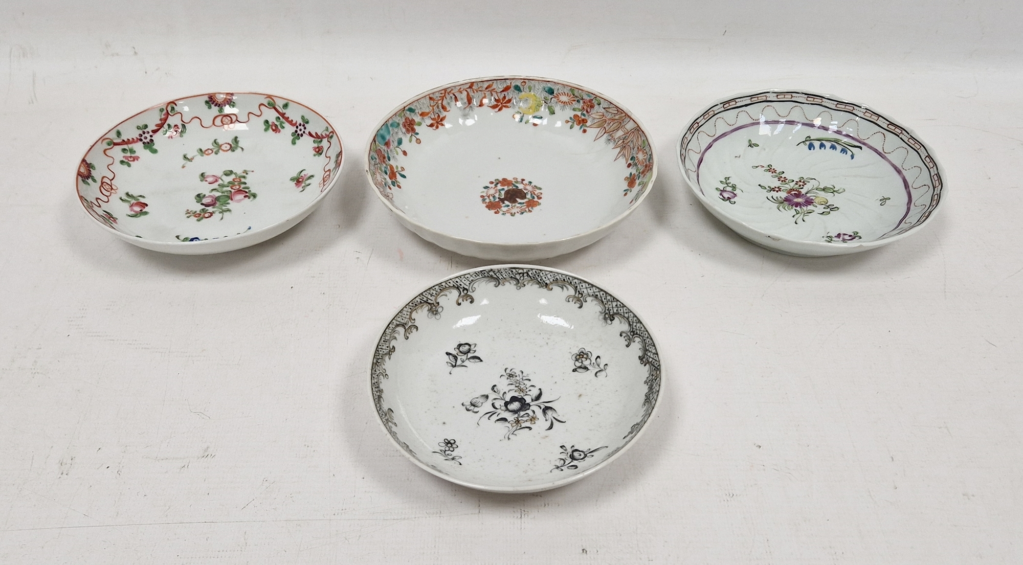 Two Chinese Export saucers comprising an example painted en grisaille with flower-sprays enriched in