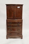 A reproduction mahogany veneer cabinet comprising a two door cupboard raised over four long
