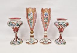 Two pairs of late 19th century Bohemian ruby tinted cased and enamelled vases, the first tapering