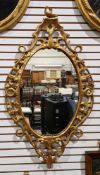 18th century carved giltwood looking glass, oval, the frame pierced and carved with fruit and