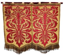 A 18th century Spanish armorial silk wall hanging embroidered with red silk cartouches,