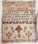 A Georgian sampler named 'Hannah Braithwaite 1825', embroidered with the alphabet, numbers, flowers,