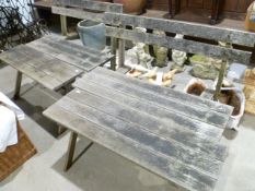 A pair of small wooden garden benches with x-cross supports and two similar matching tables/