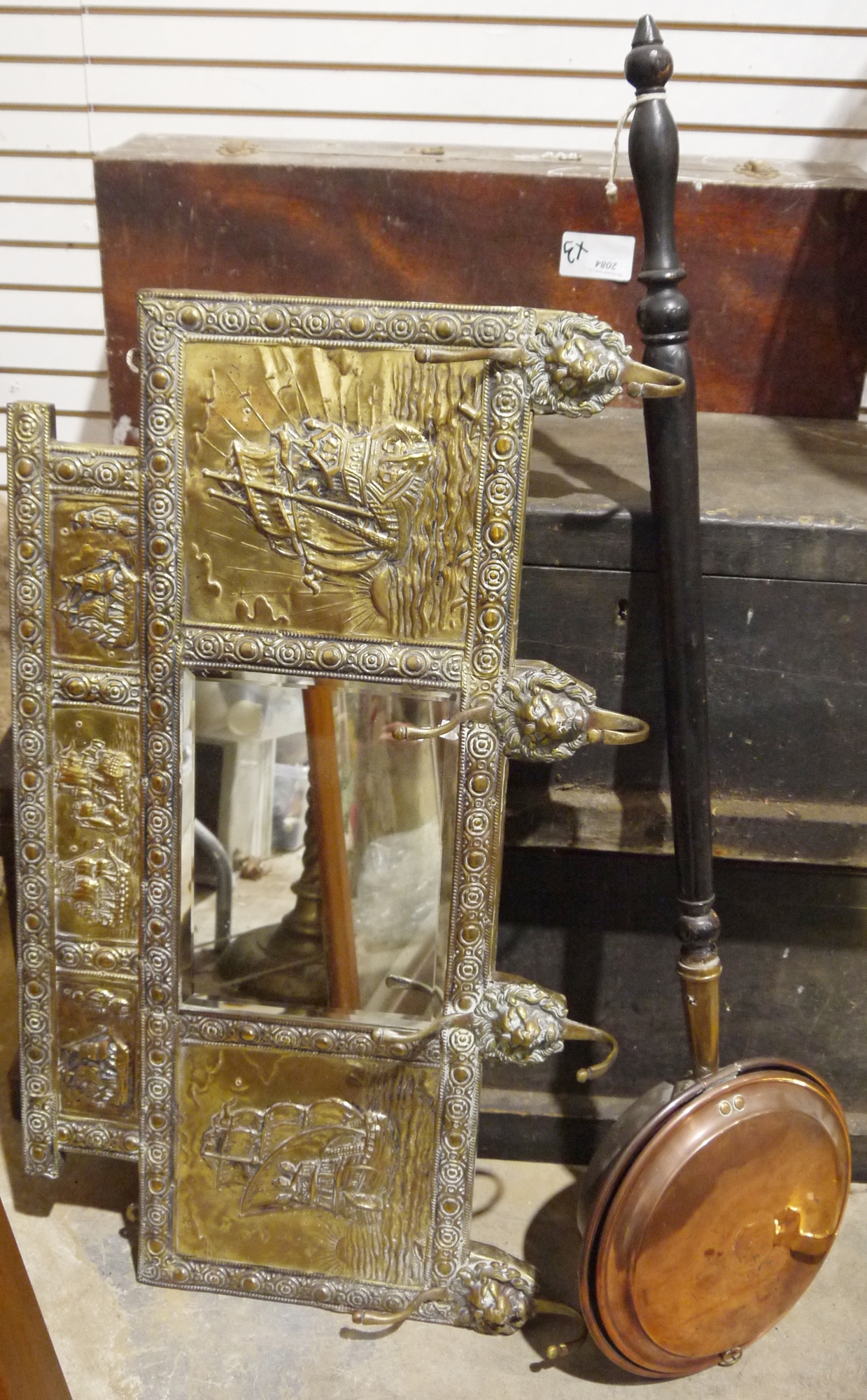 LOT WITHDRAWN Brass framed hall mirror, the frame embossed with sailing ships in the sunset, hooks