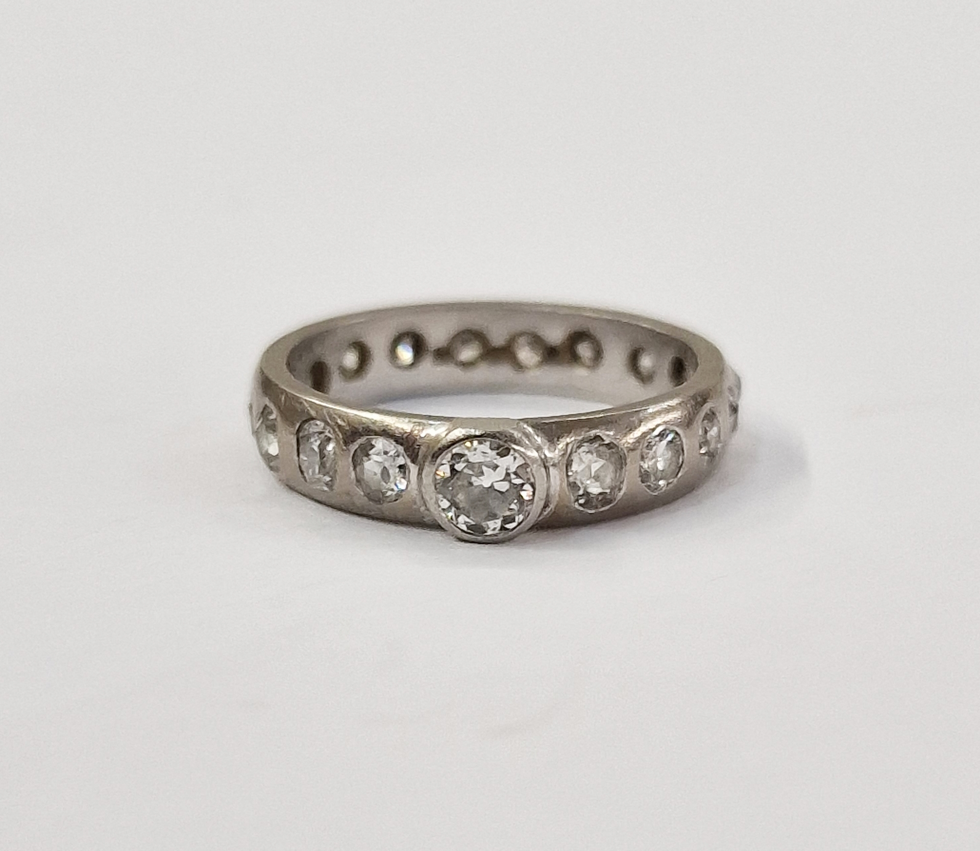Platinum and diamond ring, set central raised stone, 0.2-0.25 approx, the band set all around with