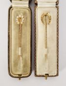 Antique gold and pearl horseshoe stickpin and another gold-coloured metal horseshoe stickpin, both
