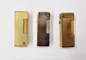 Three mid-century Dunhill lighters, comprising a silver-plated engine turned example and two gold-