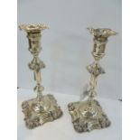 A pair of Edwardian silver table candlesticks, each with anthemion decorated shaped , square drip-