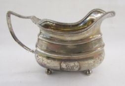 George III silver pouring jug, with reeded border, raised on four bun feet, hallmarked London
