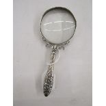 Late 19th/early 20th century silver magnifying glass, with embossed floral motifs adorning the