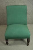 A Victorian mahogany nursing chair, upholstered in green fabric, on ring turned legs. H.85 W.61 D.