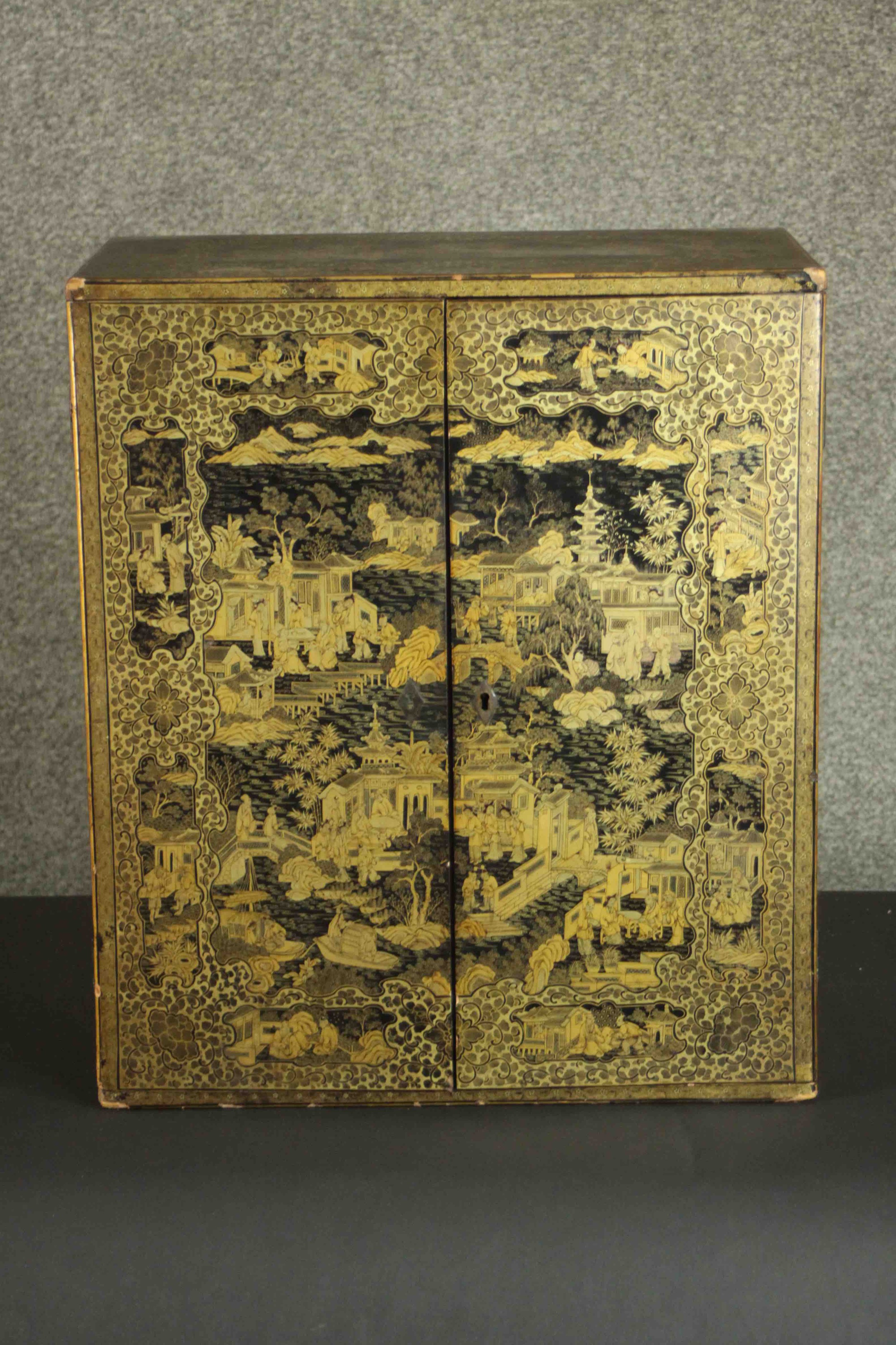 A 19th century Chinese gilt and lacquered table top cabinet with all over hand painted decoration