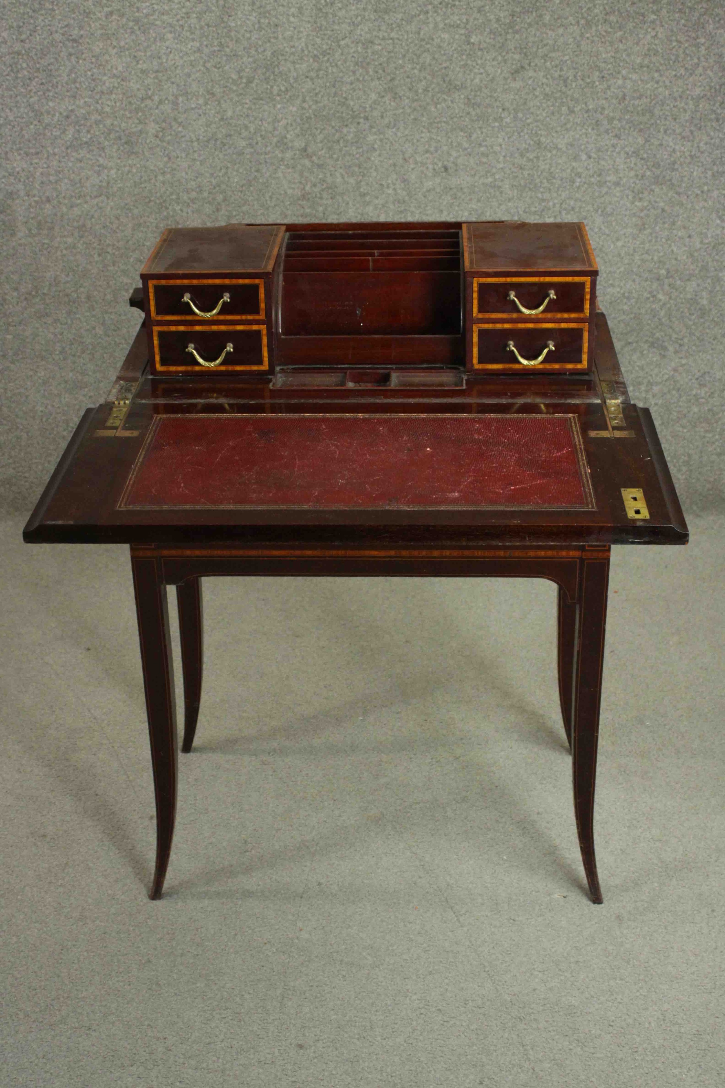 A circa 1900 mahogany and satinwood inlaid writing table, of rectangular form, the top opening to