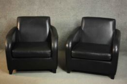 A pair of contemporary black leather armchairs, on tapering block feet.