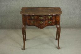 An early 18th century figured walnut lowboy of serpentine form, the top with a moulded edge over two