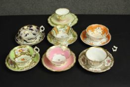 A collection of seven 19th century hand painted tea cups and saucers, including a floral form pale