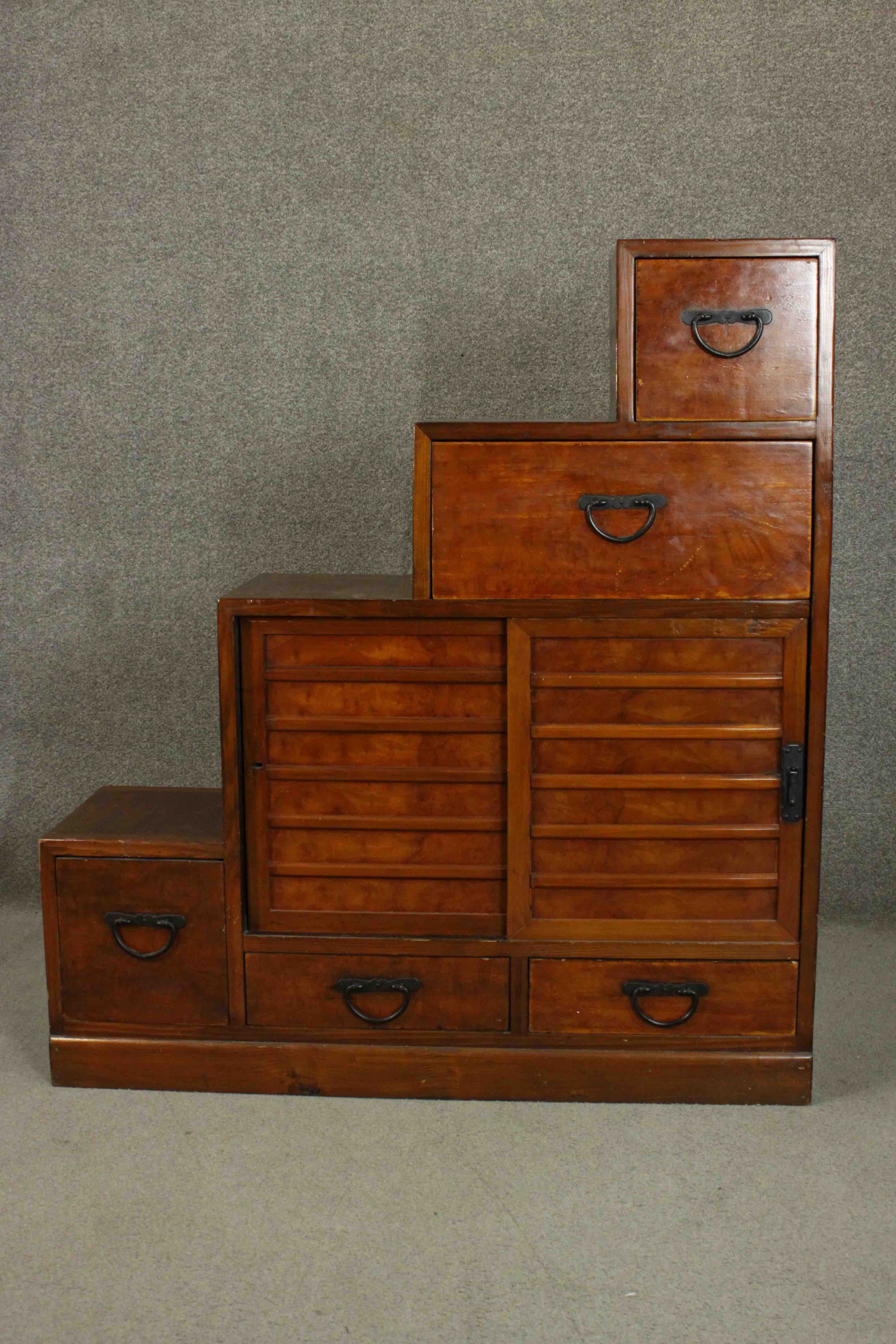 A stepped Japanese Tanshu hardwood chest, with an arrangement of five drawers.