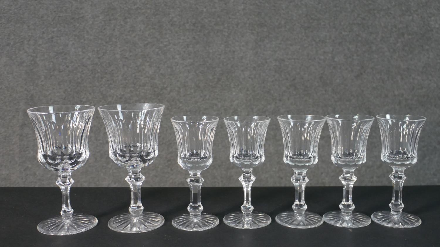 A collection of seven hand cut Waterford crystal wine and sherry glasses with star cut bases.