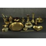A collection of brass items, including a pestle and mortar, candlesticks and chambersticks, a