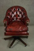 A Victorian style captain's tub chair, upholstered in burgundy leather with a buttoned back and