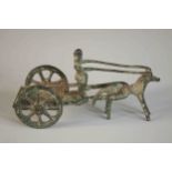 An ancient Greek style bronze of a man riding a horse drawn cart. H.8 W.14 D.6cm.