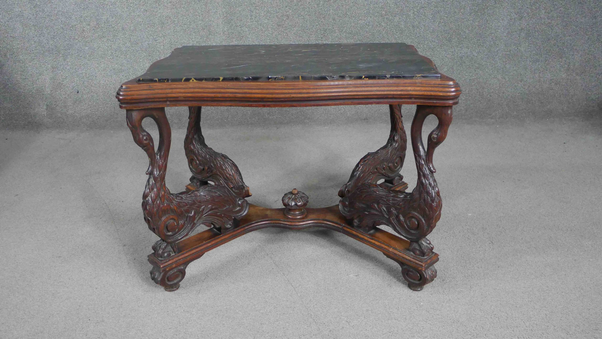 A 19th century Italian walnut centre table, of cartouche form with a marble top raised on carved