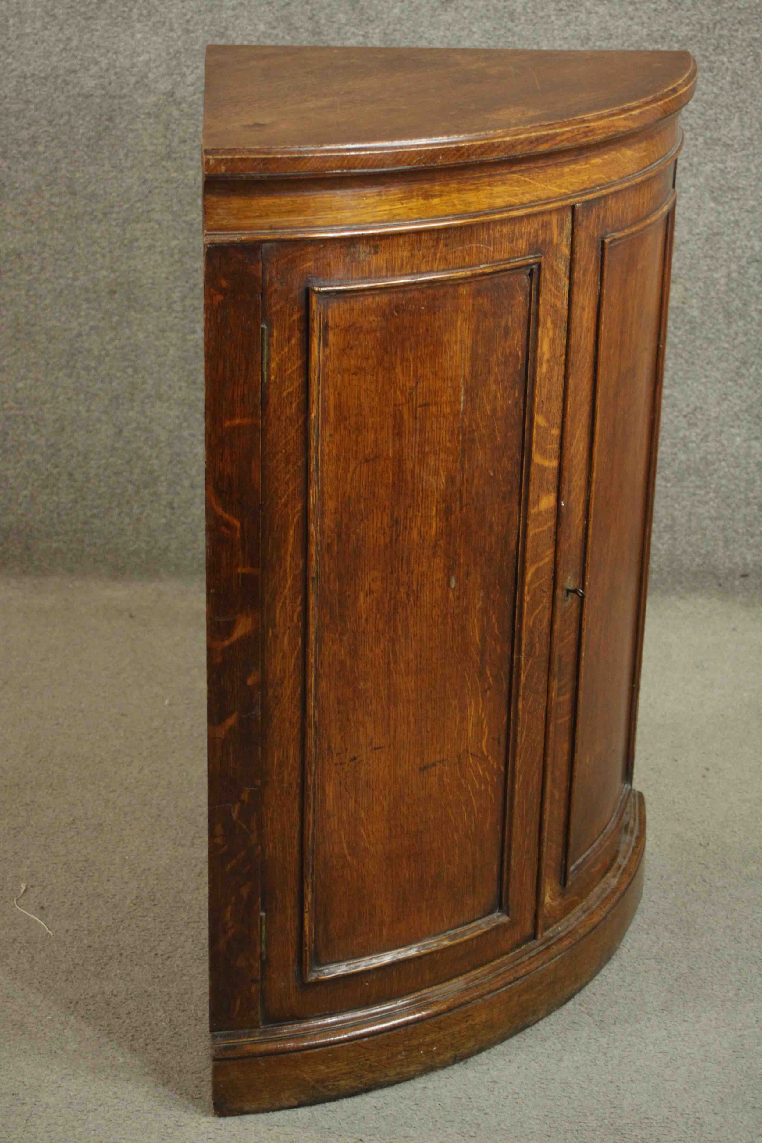 A 19th century oak bow fronted corner cabinet, with two doors opening to reveal a shelf on a - Image 7 of 7