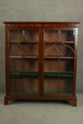 A 19th century mahogany bookcase, the two glazed doors with arched gothic tracery enclosing