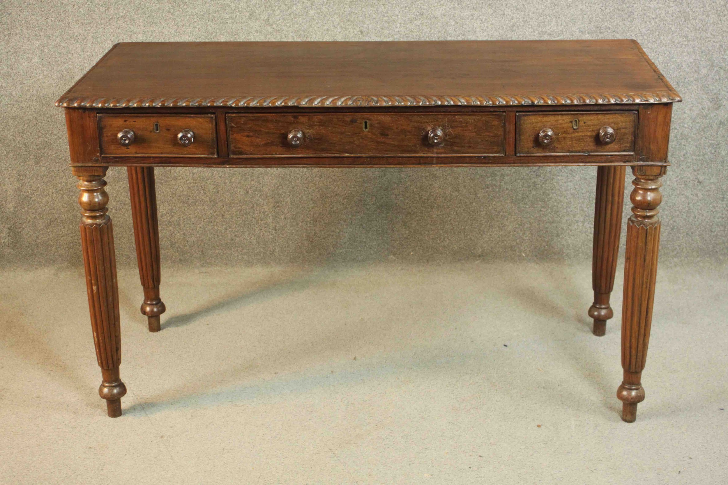 A George III Anglo-Indian side table, the rectangular top with a gadrooned edge, over three short