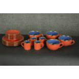 A French Genevieve Lethu porcelain set of tea and coffee cups with saucers, in hues of red and blue,