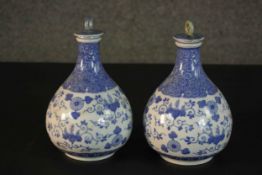 A pair of early 20th century Chinese blue and white hand painted porcelain lidded bottle vases