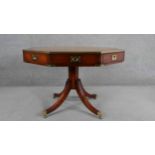 A reproduction campaign style yew wood library drum table, of octagonal form with a tooled leather