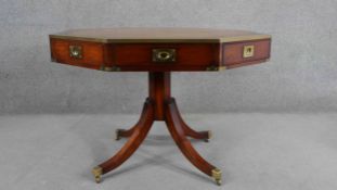 A reproduction campaign style yew wood library drum table, of octagonal form with a tooled leather