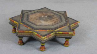 An Indian or Middle Eastern hardwood star shaped low table, with engraved flowerhead designs, with
