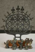 A cast iron replica of a Hittite sun disk replica on a wooden base along with a set of graduated