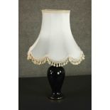 A late 20th century black glazed ceramic baluster form table lamp, with a cream coloured shade. H.75