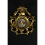 A pierced and carved giltwood framed hand painted miniature portrait on porcelain of a young lady,