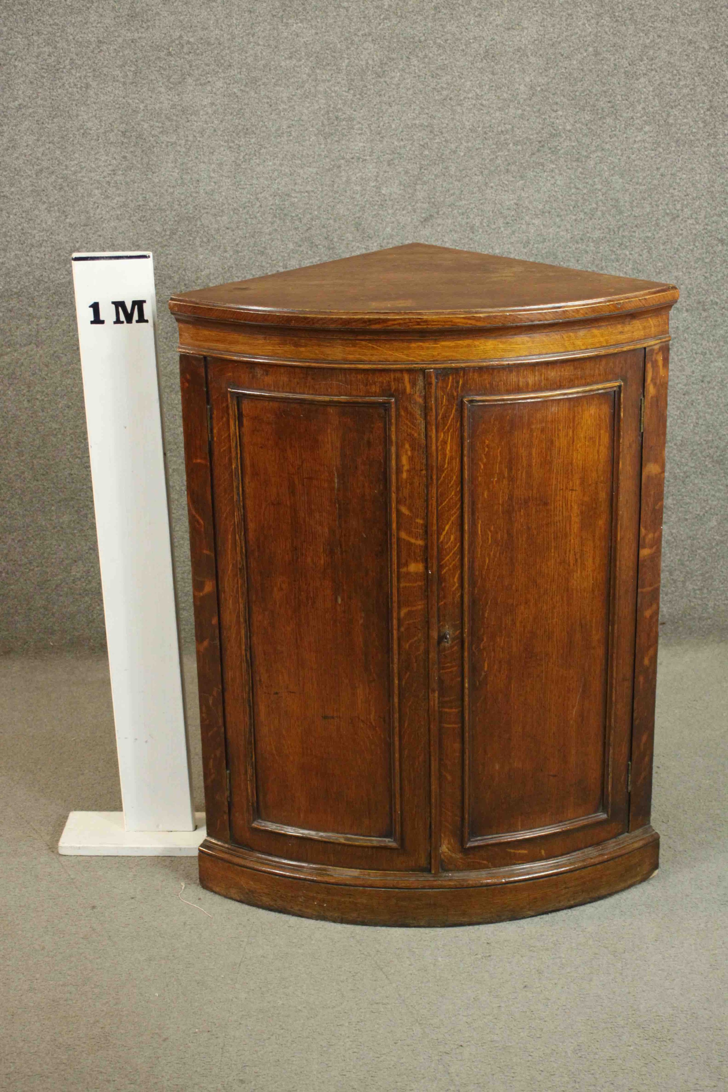 A 19th century oak bow fronted corner cabinet, with two doors opening to reveal a shelf on a - Image 2 of 7