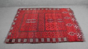 An Afghan rug with all over stylised geometric motifs on a burgundy ground. L.170 W.133cm.