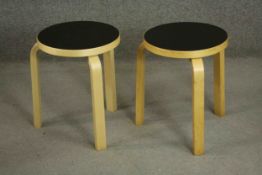 Alvar Aalto, a pair of stacking birch stools, with a circular black laminate top on three bentwood