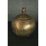 A brass table lamp, of spherical form and decorated with concentric circles. H.25 Dia.20cm.