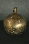 A brass table lamp, of spherical form and decorated with concentric circles. H.25 Dia.20cm.