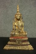 A Thai 19th century gilded and lacquered bronze figure of crowned buddha in the meditation pose.