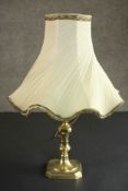 A brass table lamp converted from a candlestick, with a cream coloured shade. H.44 Dia.30cm.